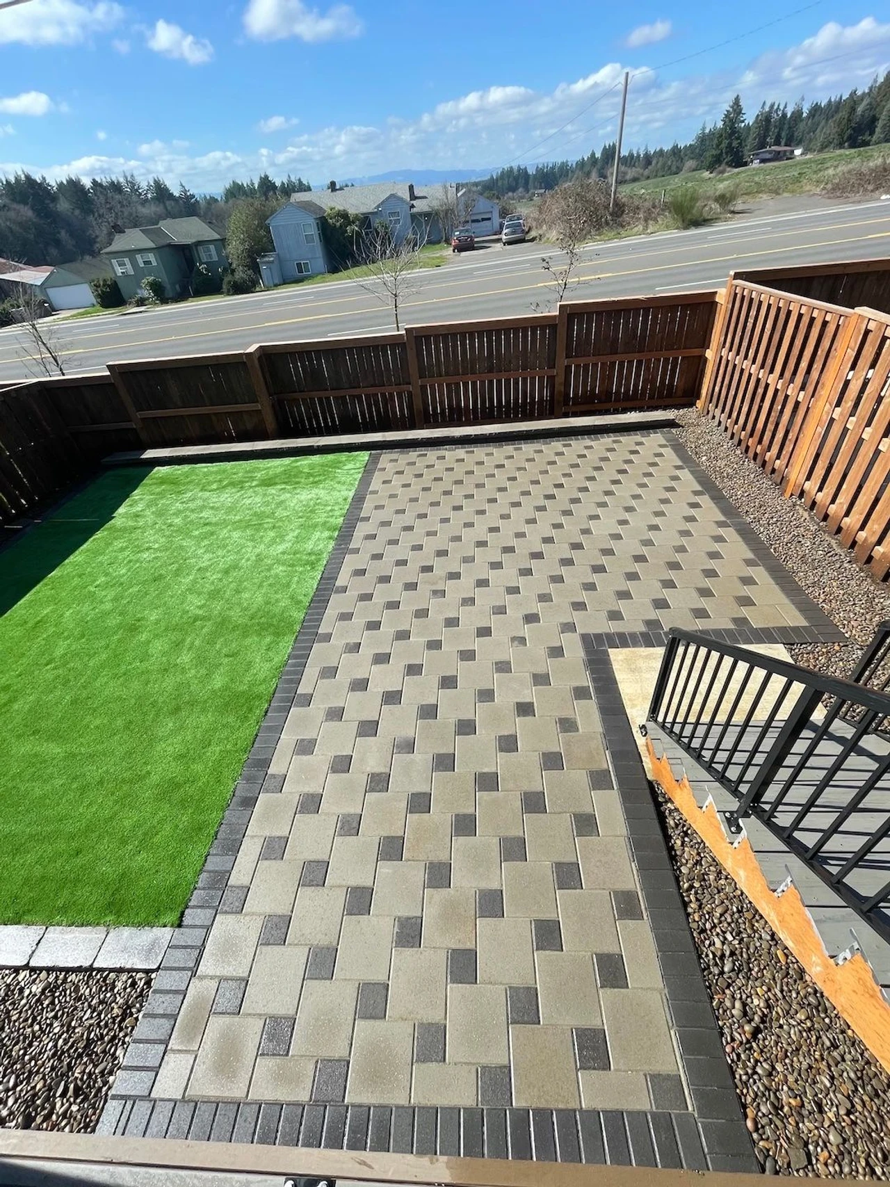 Top down look of a paver backyard with a turf yard on the left
