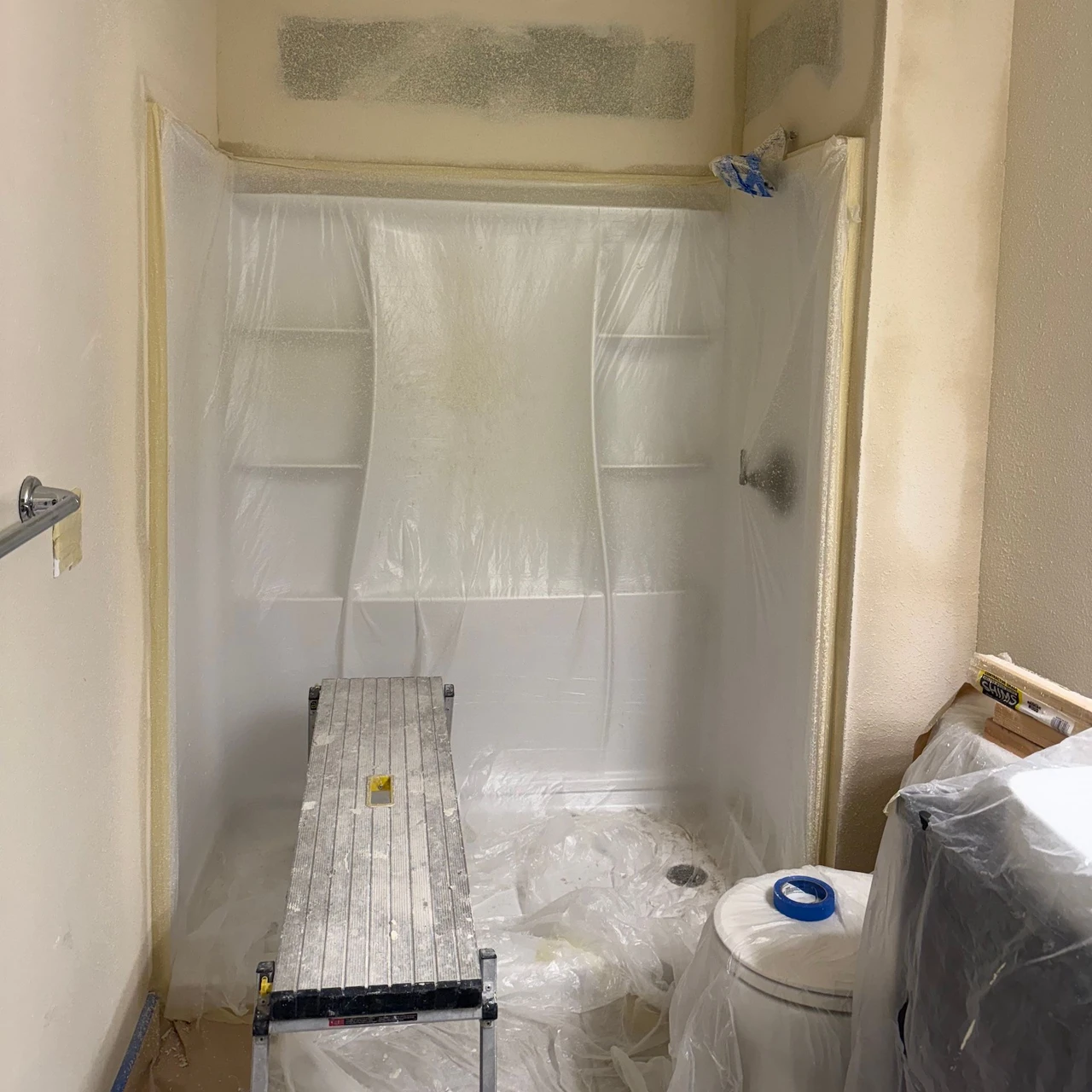 Shower and toilet covered in plastic to prepare for painting