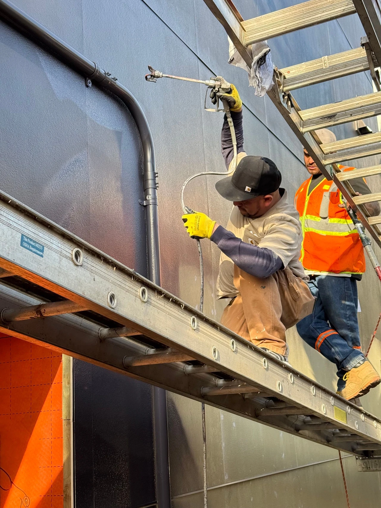 Worker painting a wall with a spray gun
