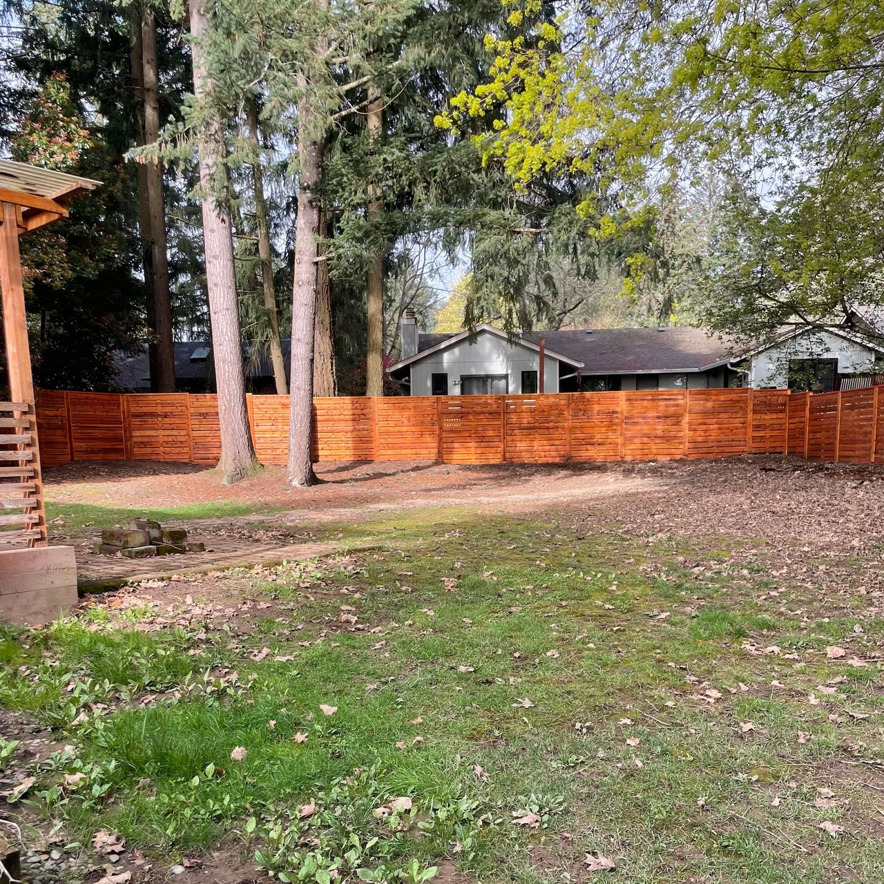 bright colored wood fence around a large backyard with sparse grass