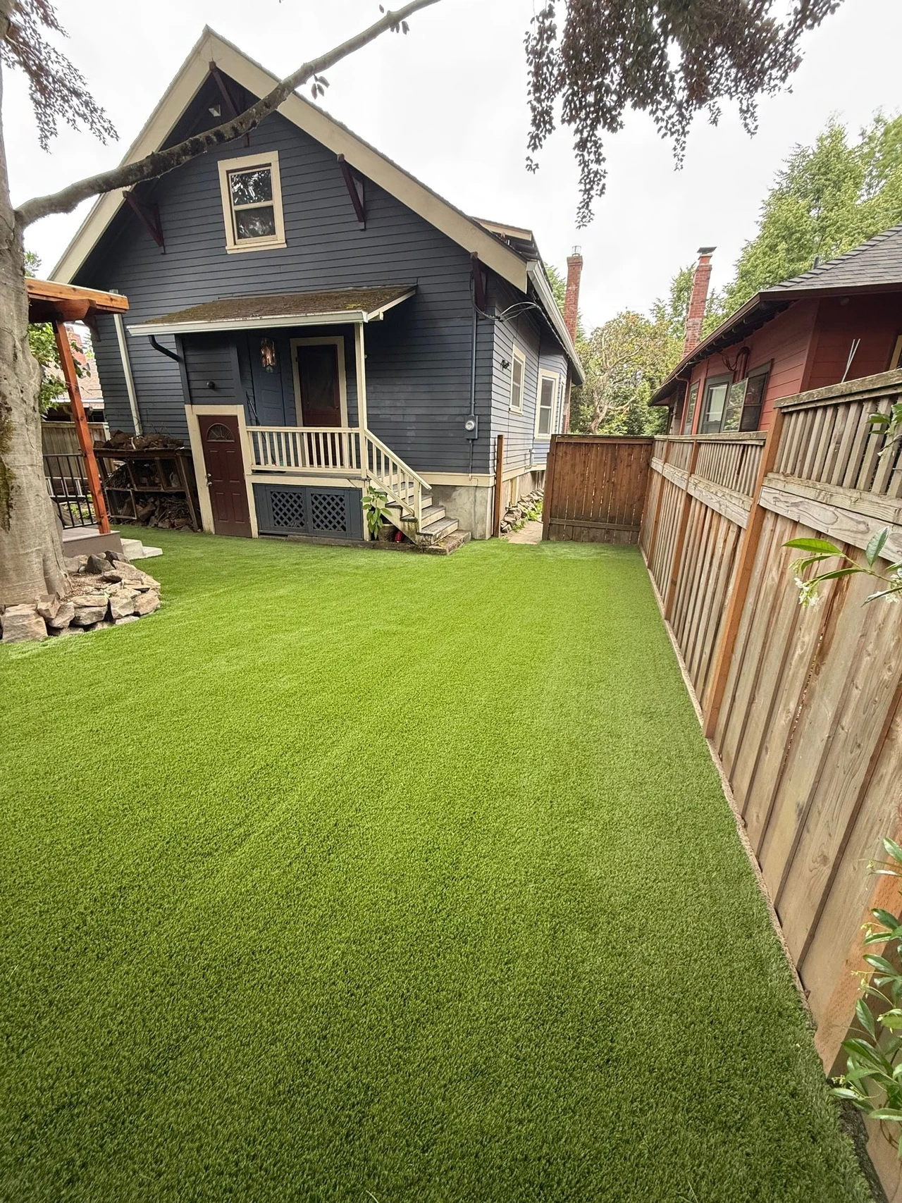 Artificial turf lawn with a house in the background