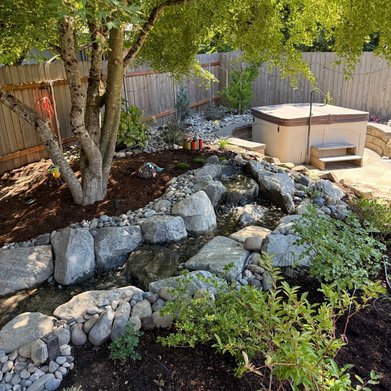 Decorative water feature with bark, trees and plants