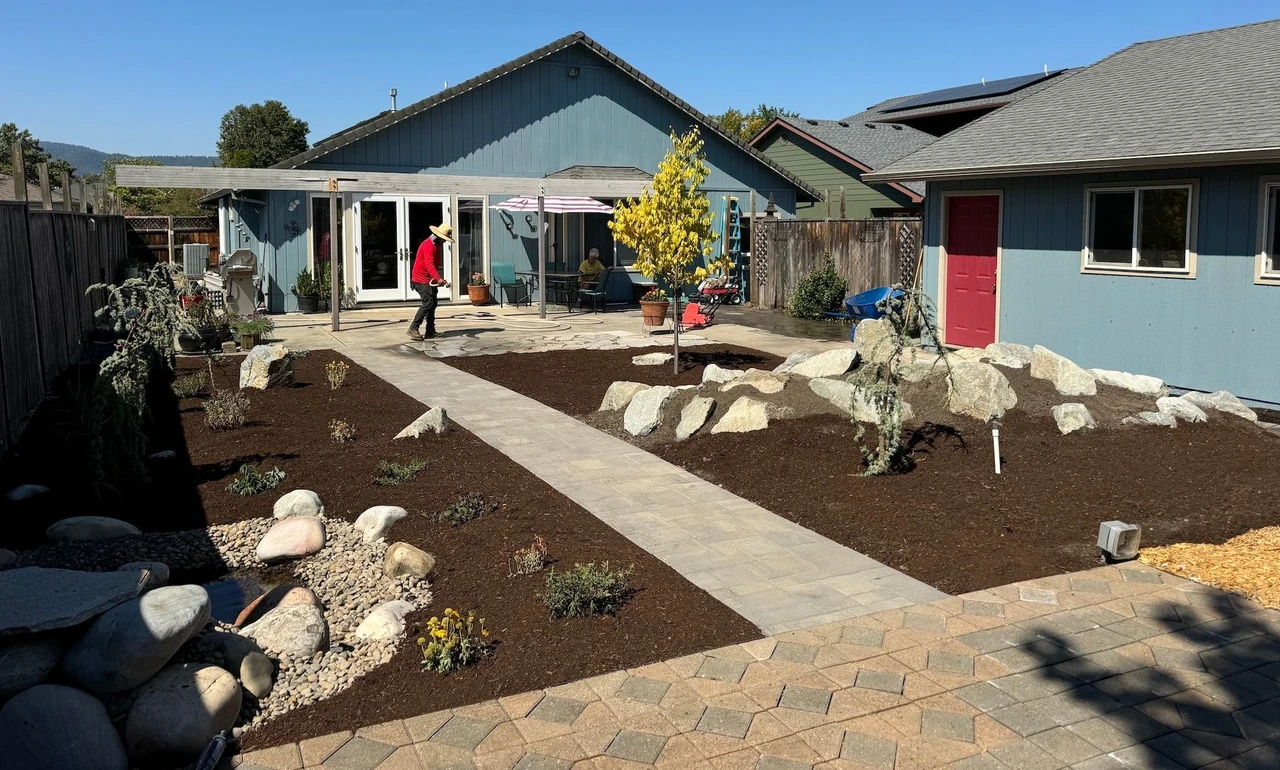 backyard no grass landscape with a small pond