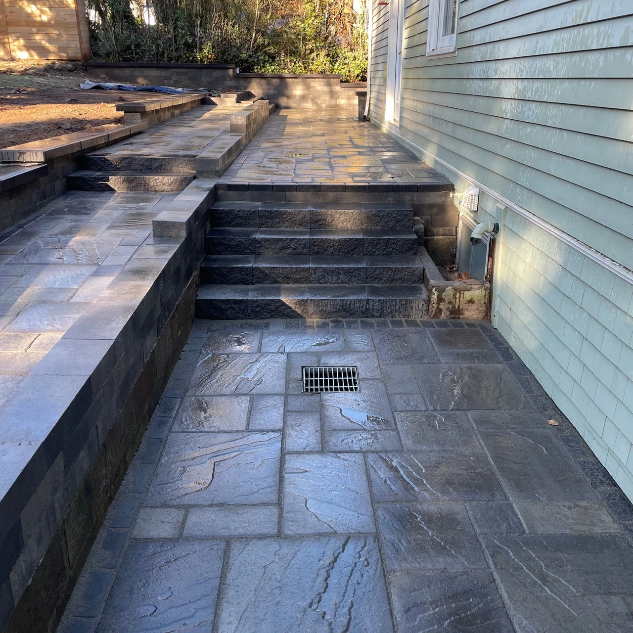 Paver walkway with stairs and borders on the side of a house