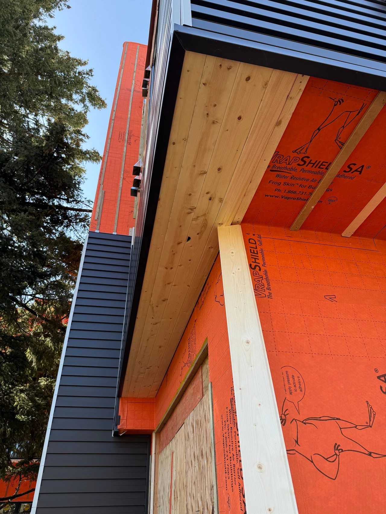 The corner of an orange apartment building with composite siding