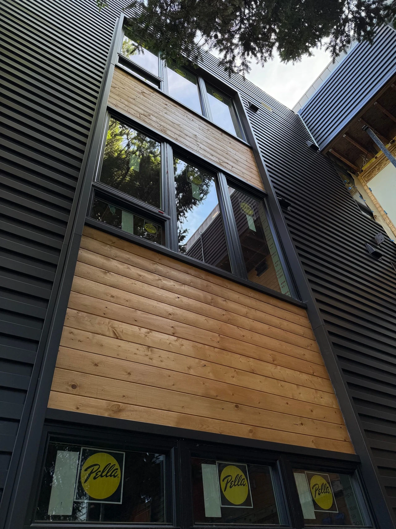 Side of a building with wood paneling and black siding material