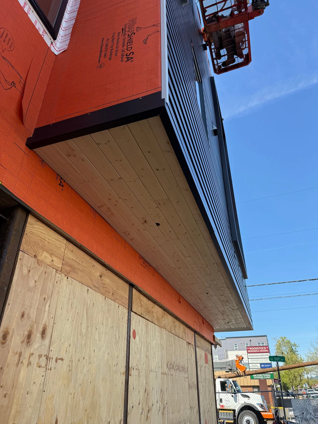 side of a building with wood and orange protective material exposed
